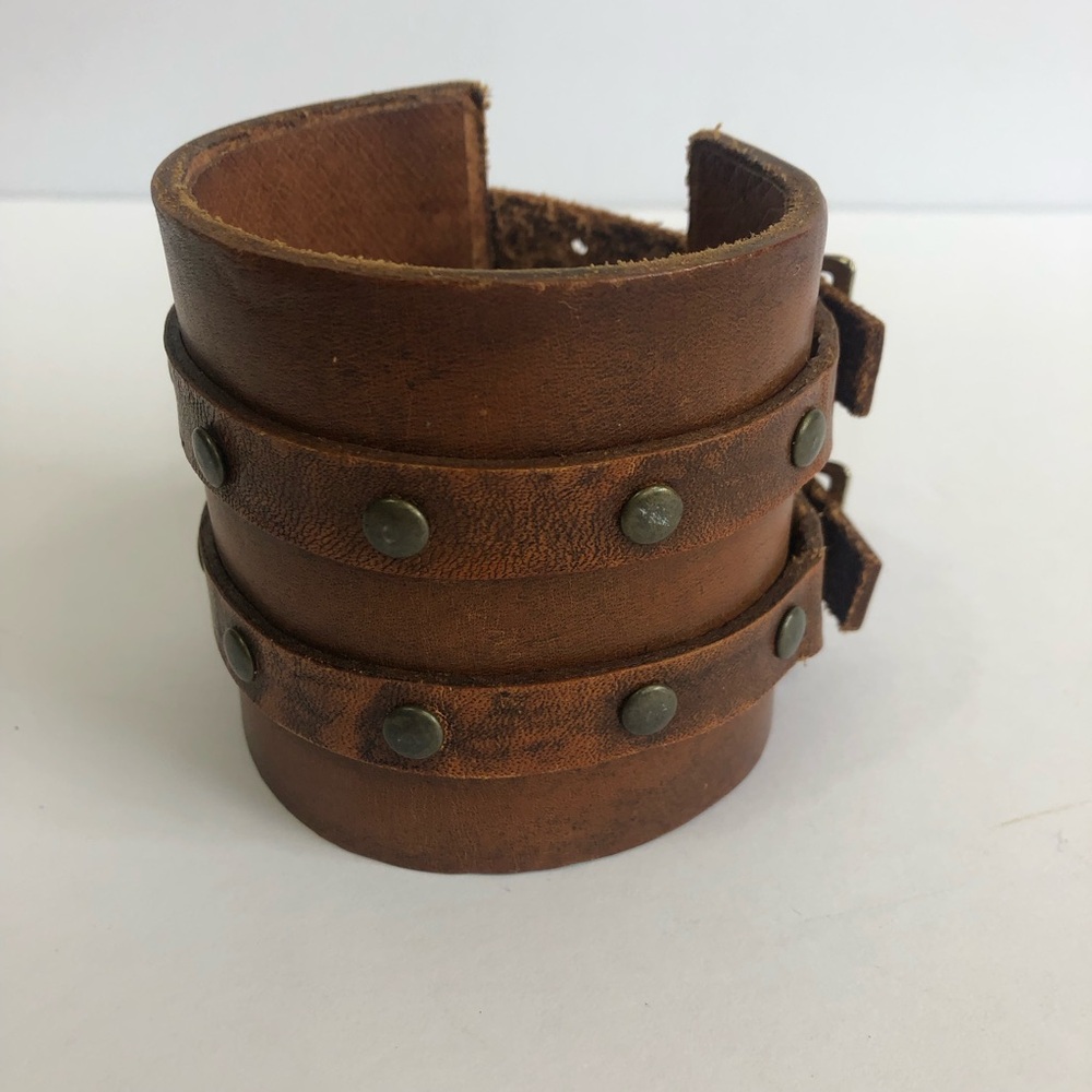 Men’s brown leather cuff bracelet with buckles and studs.